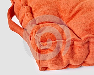 Closeup of orange velour french style seat cushion on white background