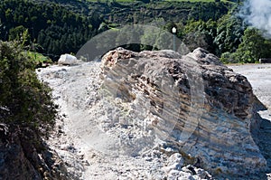 Closeup of outcrops surrounded by hills covered in greenery under the sunlight