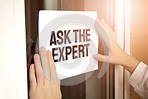 Closeup of owner holding Ask the Expert sign in store