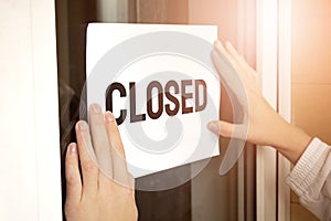 Closeup of owner holding closed sign in store