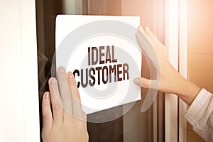 Closeup of owner holding text IDEAL CUSTOMER in store