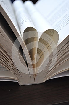 Closeup pages of an open book, with heart shaped pages