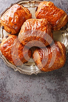 Closeup of a pain au chocolat or napolitana croissant filled with chocolate on the plate. Vertical top view