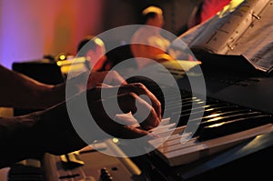 Closeup of pair of hands playing a piano in concert