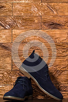 Closeup of Pair of Mens Blue Suede Semi-Brogue Boots Against Wooden Background Indoors