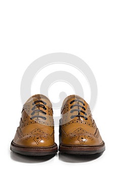 Closeup of Pair of Tanned Brogue Derby Shoes of Calf Leather with Rubber Sole Over Pure White Background