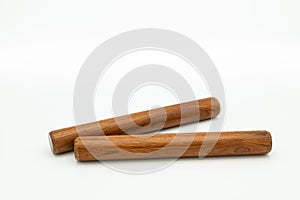 A pair of wooden claves lying on a white underground photo