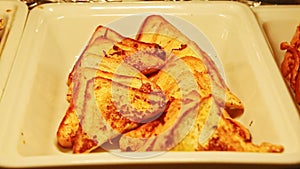 Closeup panorama from bowl with fried bread toast to plate with small pancakes