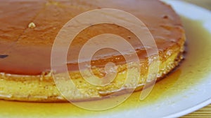 Closeup panorama at sliced round homemade soft flan with caramel syrup