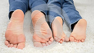 CLoseup of parent and child moving on floor at home and moving bare feet. Family having fun and playing together