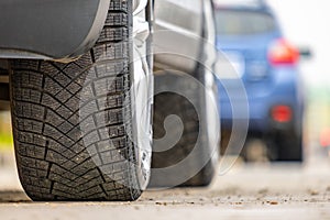 Closeup of parked car on a city street side with new winter rubber tires