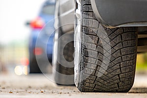 Closeup of parked car on a city street side with new winter rubber tires photo