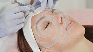 Closeup part of face, woman plucking eyebrows depilating with tweezers.