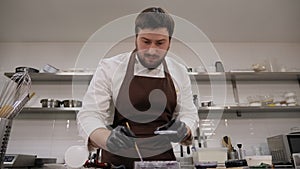 Closeup of a pastry chef makes handmade chocolates in a professional pastry shop