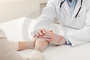 Closeup of patient and doctor hands photo