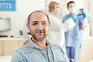 Closeup of patient man looking into camera waiting for doctors to start stomatology surgery