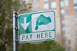 Closeup of a "Pay here" sign in a parking lot