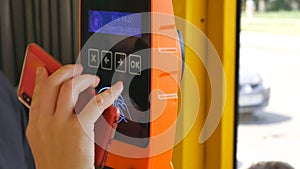 CloseUp of Paying by a telephone using Paypass Reader on a Ticket Vending Machine with Terminal. Ukraina Kiev.