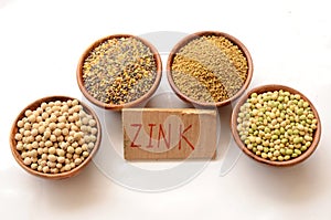 Closeup of peas, soybeans, lentil, and more, cardboard with zink written on it