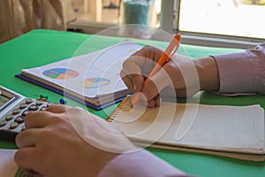 Closeup pen on paperwork accounts with man use calculator. Man hand with pen, calculator on table