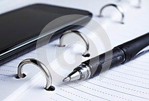 Pen, spiral notebook and cell phone