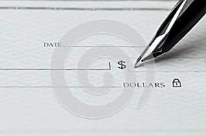 Closeup of pen writing on a blank bank check