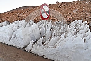 Closeup of penitentes and NO VECHICLES sign by the road in Atacama desert, Chile