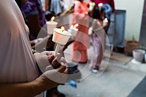 Closeup of people holding candle vigil in dark seeking hope