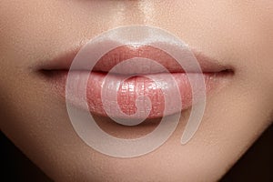 Closeup perfect natural lip makeup. Beautiful plump full lips on female face. Clean skin, fresh make-up. Spa tender lips photo