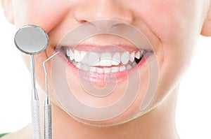 Closeup of perfect smile and dentist tools