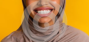 Closeup of perfect white smile of black muslim woman in headscarf