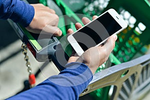 Closeup on person holding mobile smartphone in hand during shopping