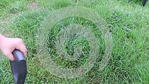 Closeup of a person mowing green grass