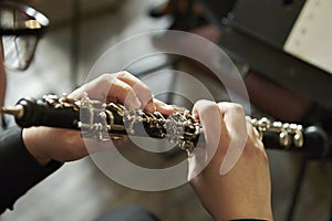 Closeup of a person playing the oboe, indoors