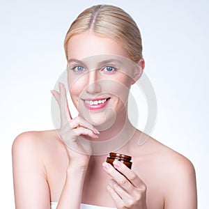 Closeup personable woman applying moisturizer cream on her face for perfect ski