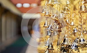 Closeup and perspective view group of small golden bells hang in Thai temple