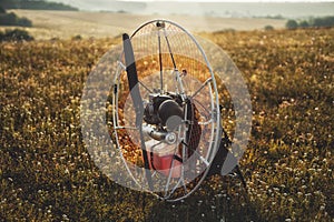 Closeup of a petrol-powered paramotor with a propeller and protection for individual paragliding flights.