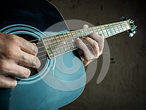 Closeup photo of an acoustic guitar played by a