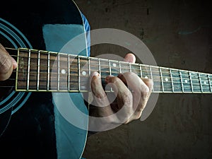 Closeup photo of an acoustic guitar played by a