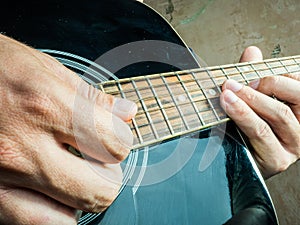 Closeup photo of an acoustic guitar played by a