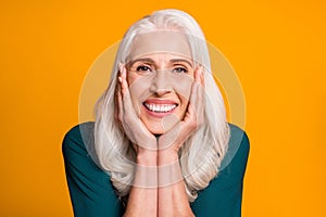 Closeup photo of amazing cheerful white haired grandma aged lady toothy smiling overjoyed arms on cheeks affectionate