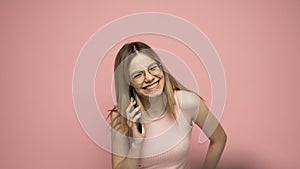 Closeup photo of attractive positive laughing young blonde woman wearing stylish yellow shirt and glasses communicating