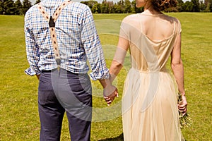 Closeup photo of backs of happy couple in love holding hands