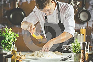 Closeup photo of baker cracking egg for dough. Retro styled imagery