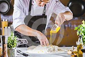 Closeup photo of baker cracking egg for dough. Retro styled imagery