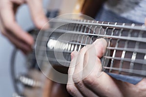 Closeup photo of bass guitar player hands, soft selective focus, live music theme