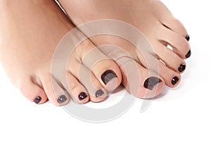 Closeup photo of beautiful female feet with red pedicure. Clean soft skin, healthy nails with gel polish, woman`s legs