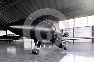 Closeup photo of Black Matte Luxury Generic Design Private Jet parking in hangar airport. Concrete floor. Business