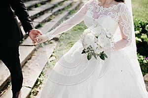 Closeup photo of bride`s dress and bouquet