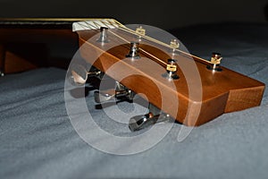 Closeup photo of a child`s acoustic guitar head stock and tuning pegs